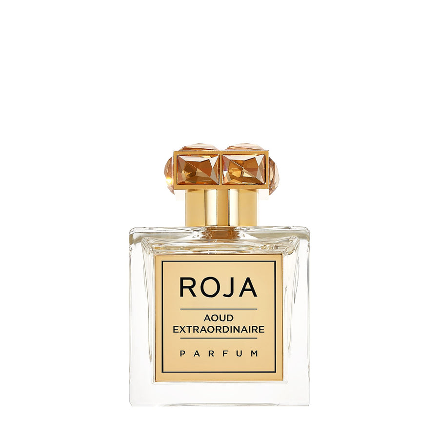 The Aoud Layering Gift Set by Roja Parfums features an elegant square bottle with a gold label. Its cap, adorned with gem-like geometric designs, adds to its luxurious allure. Inside, the light amber liquid offers the unique richness of Amber Aoud.