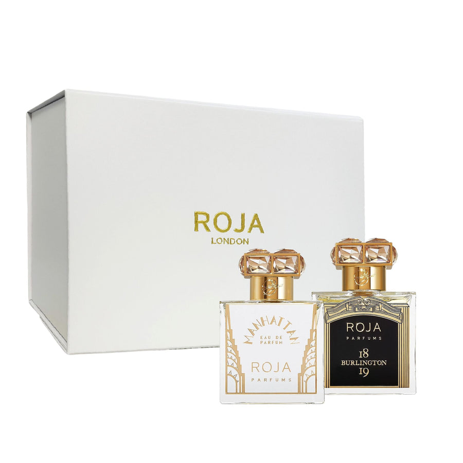 A white box labeled Roja Parfums elegantly frames the Romantic Escapes Gift Set, featuring two bottles. The left bottle is marked Manhattan, and the right one, with an ornate gold cap, is labeled Burlington 18.